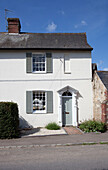 Whitewashed Sussex cottage, viewed from road, England, UK