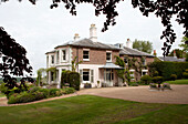 Gravel driveway and lawn of detached Sussex country house in own grounds, England, UK