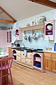 Range oven in pastel pink and blue kitchen of Sussex country house, England, UK