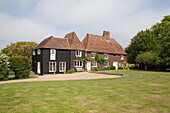 Lawned exterior and driveway to Maidstone farmhouse in Kent, England, UK