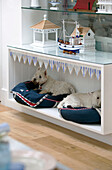 Eingebaute Hundebetten mit weißen Terriern unter Regalen mit nautischen Gegenständen in einem Haus in Dulwich London England UK