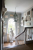 Historische Stuckarbeiten und männliche Statue im Bogenfenster des Treppenhauses eines Landhauses in Sussex England UK