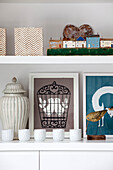Artwork and ornaments on white shelving in contemporary Surrey country home England UK