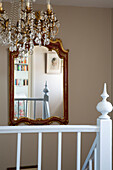 Cut glass chandelier and mirror in staircase of Sussex home England UK