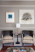 Pair of vintage armchairs and artwork in living room of London home, England, UK