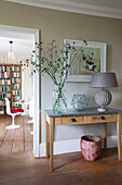 Lamp and artwork with dried flowers on side table in Herefordshire home, England, UK