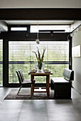 Leather bench seat and chairs at dining table in window of contemporary SW London home, England, UK