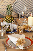 Lit tealights at place setting with pineapple on Chilterns dining table, England, UK