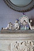 Figuren und Uhr auf steinernem Kaminsims in einem Haus in Burwash, East Sussex, England, Vereinigtes Königreich