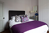 Lila Decke auf einem Doppelbett mit eingebautem Stauraum in einem Londoner Stadthaus England UK