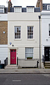 Black wrought iron railings and cream facade of London townhouse, England, UK