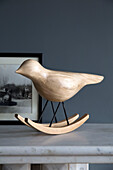 Wooden bird with framed black and white photograph on marble mantlepiece in contemporary Sussex home, England, UK