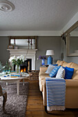 Striped blue blanket on yellow sofa in living room with coffee table in UK home