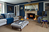 Wingback armchair at fireside in blue living room of London home,  England,  UK
