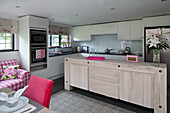 Kücheninsel aus hellem Holz mit integriertem Ofen in einem Landhaus in Sussex, England, Vereinigtes Königreich