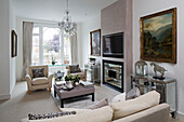 Glass chandelier in living room with arched window and gilt-framed artwork in contemporary London home   UK