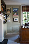 Framed artwork and wooden desk in Surrey study,  England,  UK