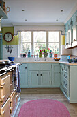 Light blue fitted kitchen with range oven in Sussex home  England  UK