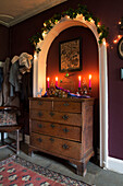 Beleuchtete Kerzen auf Holzkommode mit Lichterketten auf Torbogen in King's Lynn Korridor Norfolk England UK