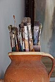 Assorted paintbrushes in pottery jug,  Berkshire home,  England,  UK
