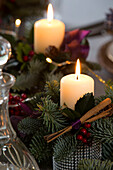Beleuchtete Kerzen mit Zimtstangen in einem Haus in Chobham zu Weihnachten Surrey England UK