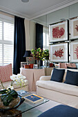 Artwork on mirrored wall with blue cushions and curtains in London townhouse   England   UK