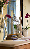 Drahtuhr und Kerzenständer mit Orchidee auf Anrichte in Sandhurst Landhaus Kent England UK