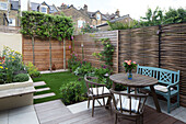 Gartenmöbel und Zaun im Außenbereich eines städtischen Hauses in London, England, UK