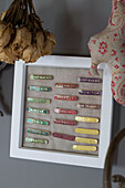 Assorted school badges in display case with dried roses in Wokingham cottage Berkshire UK