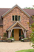 Wooden porch on brick exterior of Surrey new build England UK