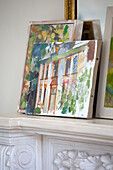Artwork canvases on mantlepiece in Sussex country house England UK