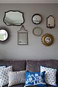 Vintage-Spiegelsammlung über dem Sofa mit blauen und weißen Kissen UK home