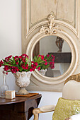 Circular mirror with red flowers on drop leaf table in Var farmhouse Provence France
