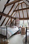 Zwillingsbetten aus schwarzem Metall in einem Fachwerk-Dachzimmer in einem Haus in Kent, England, Vereinigtes Königreich