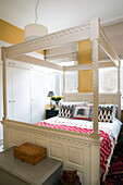White four poster bed with blanket box and casket in London townhouse apartment UK