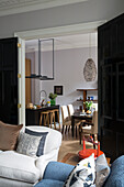 Black double doors between living and dining rooms in London townhouse UK