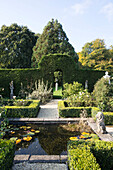 Parterre garden with pond in grounds of Grade II listed 16th century Hampshire cottage England UK