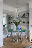 Glass dining table and collection of wooden birds with large mirror in Sussex beach house England UK