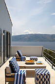 Sessel mit Fußhockern auf der Balkonterrasse einer Villa in Ithaka mit Blick auf das Meer, Griechenland