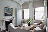 Glass pendant shade in neutral living room with window seats in London townhouse England UK