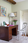 Painted chair at wooden desk in Gloucestershire farmhouse England UK