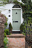 Hellgrüne Haustür und gemauerter Weg zu einem Haus in Sussex England UK