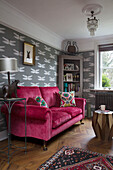 Novelty lamp base and pink sofa with corner cabinet and dragonfly wallpaper in Sussex home England UK