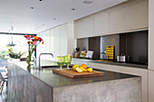 Sliced lemons on polished concrete kitchen island in open plan London townhouse England UK