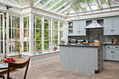 Light grey fitted kitchen with stainless steel extractor in conservatory extension of London townhouse UK