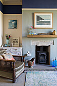 Polished wooden armchair at fireside with coal bucket in Yorkshire home England UK