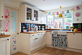 Colourful fitted cottage kitchen with black tiled splashback Kidderminster Worcestershire England UK