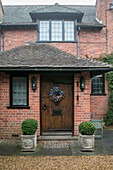 Christmas wreath on wooden front door of Berkshire home in winter UK