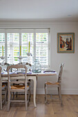 Painted chairs at dining table in West Sussex home