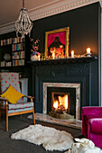 Armchair at fireside with candles on mantlepiece in Hove apartment East Sussex UK